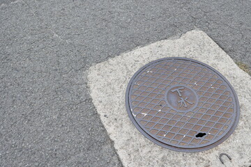 道路に設置された下水マンホールの蓋と舗装面