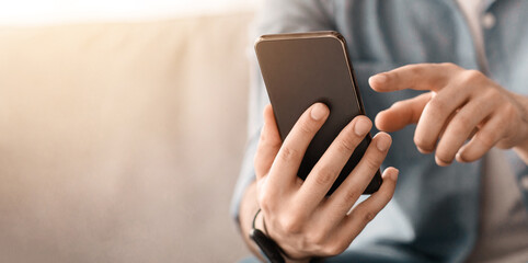 Modern smartphone in unrecognizable man hands. Guy using brand new smartphone, touching screen, checking newest mobile application, cropped of man holding device, selective focus, free space