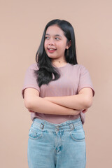 Asian woman with long black hair wearing casual t-shirt and denim jeans, smiling confidently while looking aside, showing modern and youthful style.