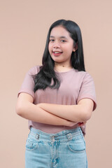 Asian woman with long black hair wearing a casual t-shirt and denim jeans, smiling with arms crossed, expressing confidence and modern youthful lifestyle.