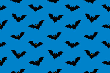 Seamless pattern with flying black bats on blue background. Halloween spooky vector illustration