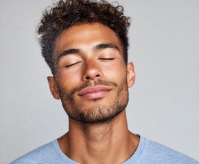 A man with closed eyes, a peaceful expression, and a light mist on his face, is the perfect example of tranquility in a simple portrait.