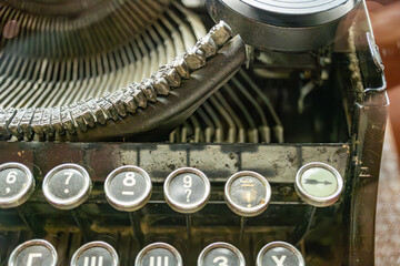 Close-up image of an antique manual typewriter, keys arranged in a QWERTY layout with visible...