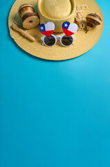 Traditional chilean toys, straw hat, and heart-shaped glasses with chilean flag celebrating chilean independence day on a vibrant blue background