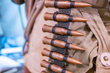 Close-up of a cloth ammunition pouch containing copper-colored bullet tips, arranged neatly...