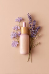 A pale peach background displays a light pink serum bottle with a light brown wooden dropper.  Small, delicate, lavender-purple flowers and sprigs of lavender surround the bottle.