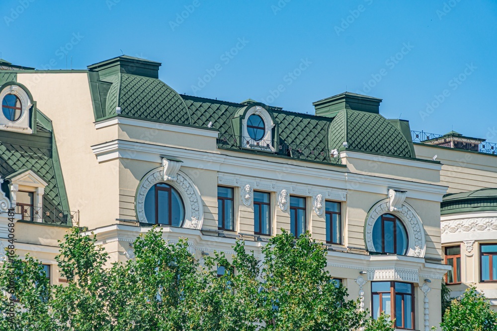 Poster a three-story, beige classical-style building with ornate window frames, balconies, and cornices shu