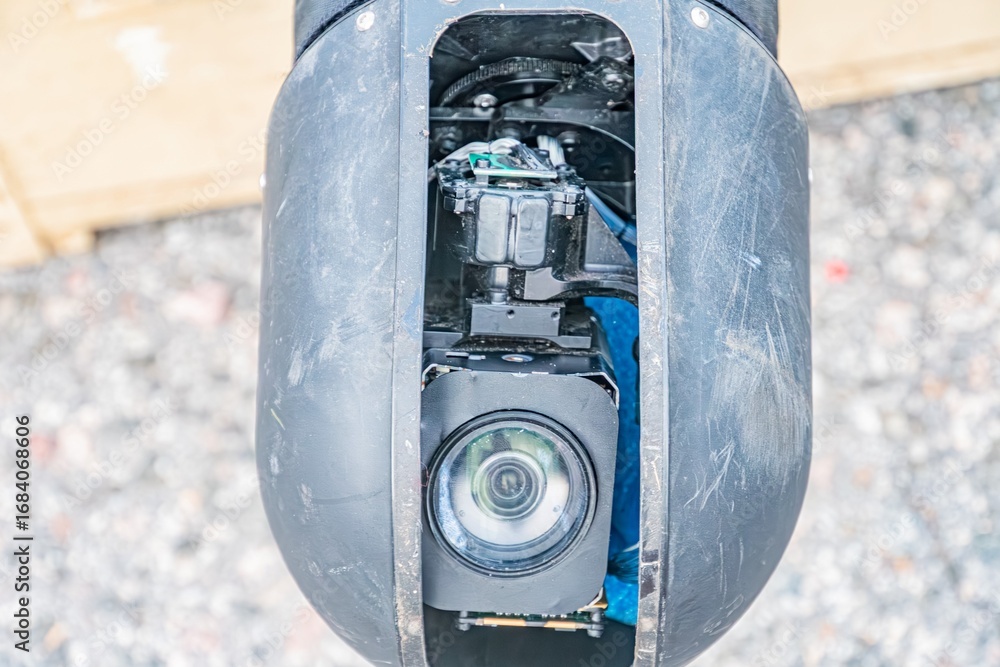 Poster close-up view of a disassembled black drone with camera, electronic components visible shallow depth