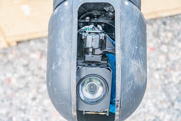 Close-up view of a disassembled black drone with camera, electronic components visible Shallow...