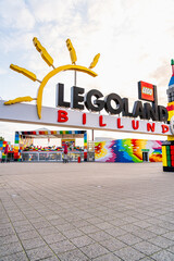 Naklejka premium A vibrant Gateway and entrance adorned with colorful structures welcomes visitors to Legoland Billund. The empty square offers a serene view during a warm summer evening after closing time