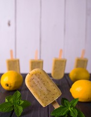 Lemon popsicles on dark wood