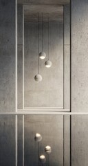 Light fixtures hang from a concrete wall, reflected in a mirrored surface