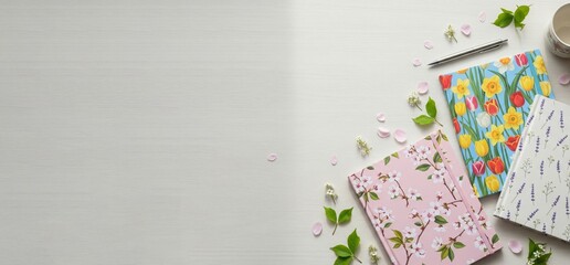 Obraz premium Flat lay of spring-themed notebooks and stationery on a light background