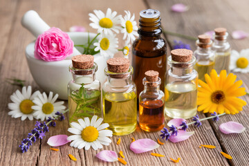 Spa Essential Oils Bottles with Flowers on Wooden Table