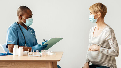 Coronavirus treatment, injection, vaccination. Millennial pregnant woman in protective mask talking...