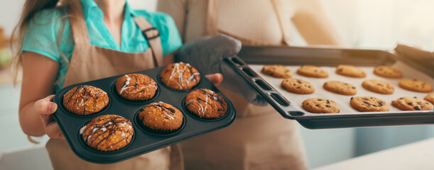 Traditional Family Recipe. Smiling mature woman and cheerful little girl holding tasty fresh baked...