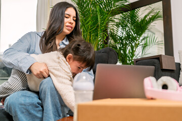 Young mother managing work and crying baby at home office