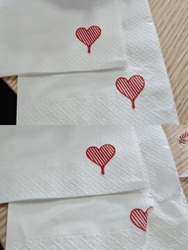 Detail Tekstur Tisue Putih dengan Bordir Kecil Berbentuk Hati Merah yang Romantis