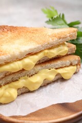 Tasty sandwiches with melted cheese and parsley on table, closeup