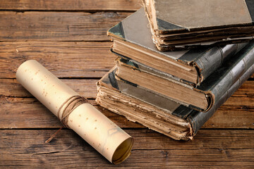 Old rolled paper scroll and books on wooden table