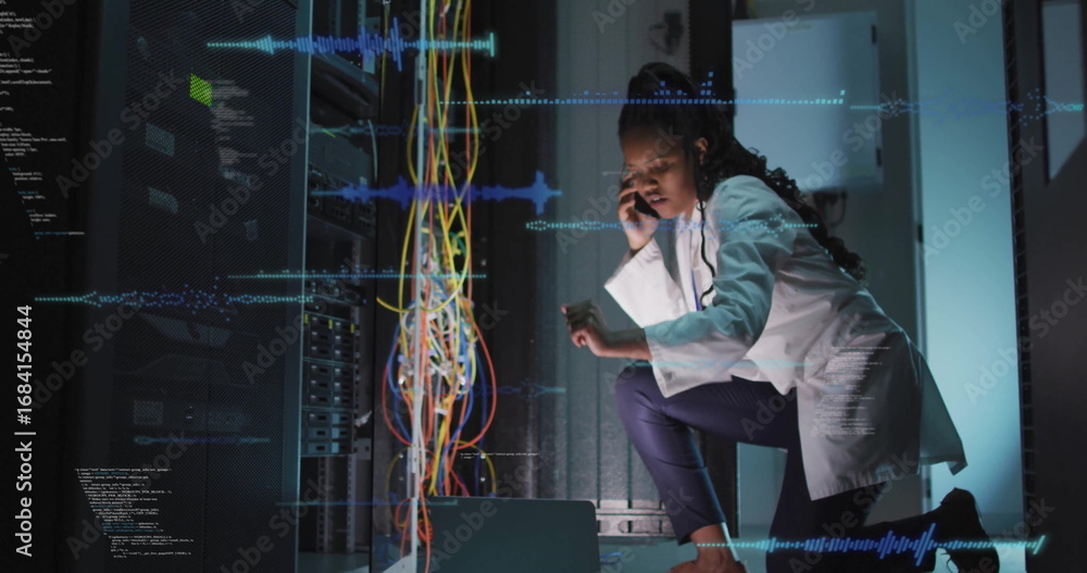 Poster engineer wearing lab coat inspecting multicolored cables in data center with smartphone, copy space