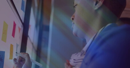 Writing man in blue blazer annotating board with stylus at office sticky-note shapes, copy space