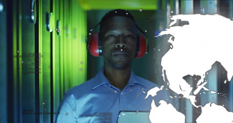 Engineer in blue shirt and red headset monitoring racks in data center, with world map overlay