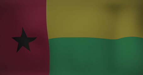 Displaying national flag of Guinea-Bissau fluttering against neutral plain backdrop, fabric detail