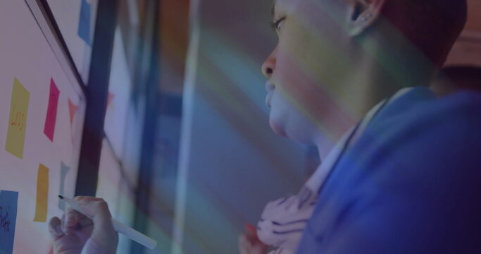 Writing man in blue blazer annotating board with stylus at office sticky-note shapes, copy space