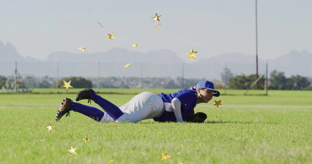 Lying baseball player wearing blue cap, jersey holding glove on grass field with stars, copy space