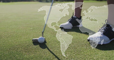 Aligning golfer's putter head behind golf ball on putting green, with golf shoes, world map overlay