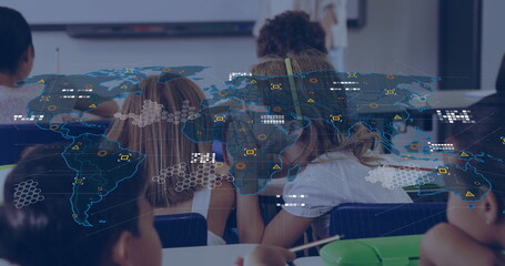 Teaching teacher guiding student writing at desks by whiteboard with yellow headphones, map overlay
