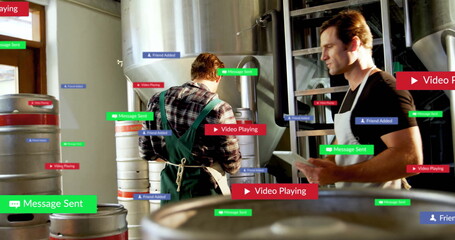 Holding tablet, brewery worker wearing apron inspecting tanks with overlays in brewery, copy space