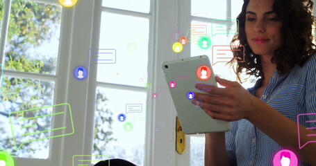 Holding tablet woman with striped shirt sitting home by white window with chat bubbles, copy space