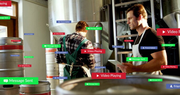 Holding tablet, brewery worker wearing apron inspecting tanks with overlays in brewery, copy space