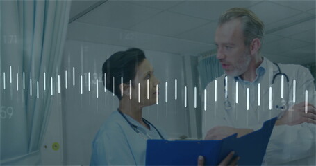 Doctor and nurse in scrubs, lab coat, discussing in ward with blue clipboard by privacy curtains