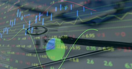 Resting stethoscope on pad displaying healthcare finance data at desk, with market graphs overlay