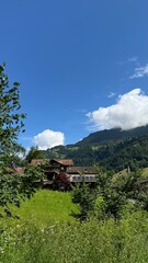 Obraz premium Swiss Village in Alps with Waterfall and Mountains