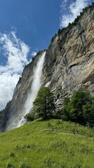 Swiss Village in Alps with Waterfall and Mountains