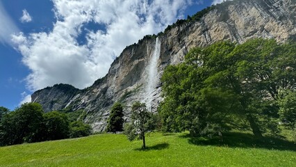 Swiss Village in Alps with Waterfall and Mountains