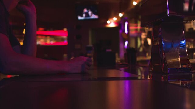 Man sitting at bar watching tv
