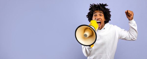 Breaking news. Agitated black teenager shouting into megaphone over violet studio background....