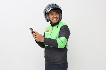 Asian online taxi driver holding smartphone while looking at empty space isolated over white background