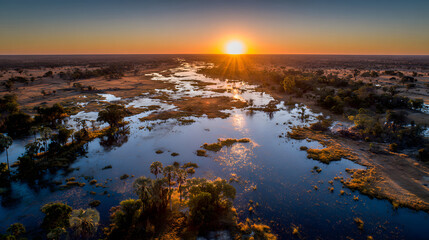 Obraz premium Botswana's Okavango Delta at Sunset Aerial View of Waterways and Islands Reflecting Golden Light Over the Serene Landscape