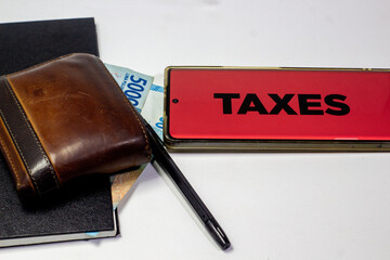 Tax payment concept with wallet money and taxes sign on white