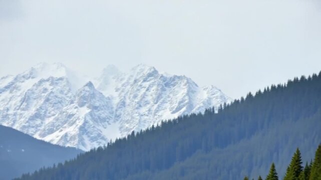 The sky is cloudy and the mountains are covered in snow