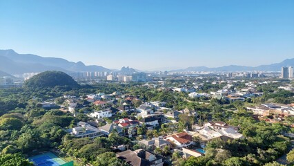 Panoramic View of a Lush Green Cityscape with Mountains and Blue Sky