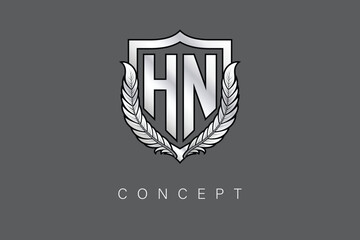 HN Creative Initial Letter Logo with Shield and Laurel Wreath Silver Metallic Branding Emblem on Gray Background.