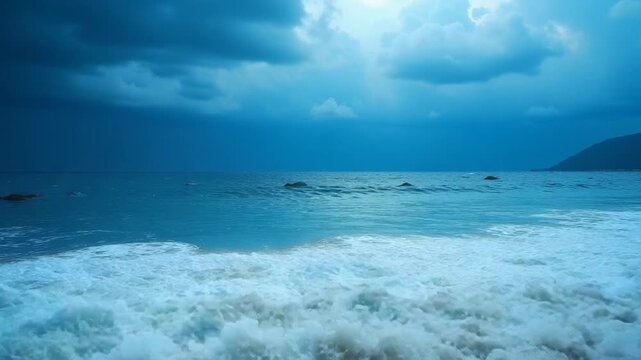 A stormy sea with crashing blue waves under dark clouds at the beach in Lustica Bay Montenegro. The powerful ocean swells and dramatic sky create a breathtaking display of natures force.