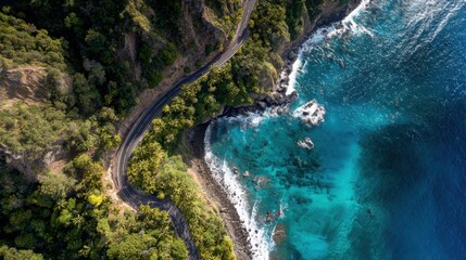 Obraz premium Aerial Drone View of Coastal Road Curving Along Rocky Shoreline with Turquoise Ocean Waves